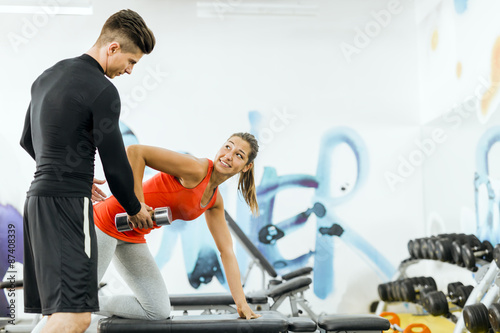 Young male trainer giving instructions to a woman in a gym