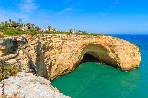 Cliff cave and turquoise ocean on coast of Portugal near Carvoeiro town, Algarve region