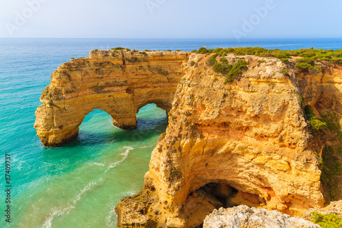Rock cliff arches on Marinha beach and turquoise sea water on coast of Portugal in Algarve region