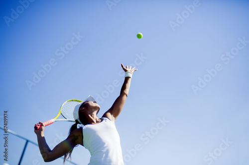 Canvas Print Beautiful female tennis player serving
