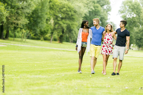 Cheerful friends walking in a park and having a good time