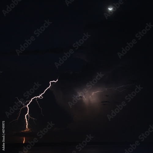 lightning hit behind amazon river, night, with crescent moon