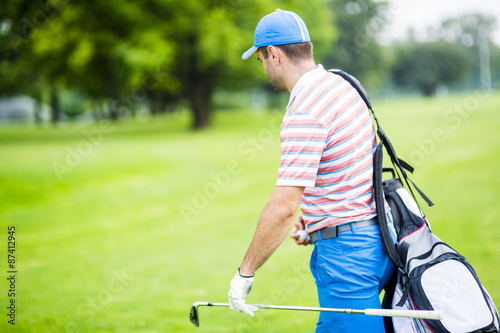 Golfer carrying his equipment