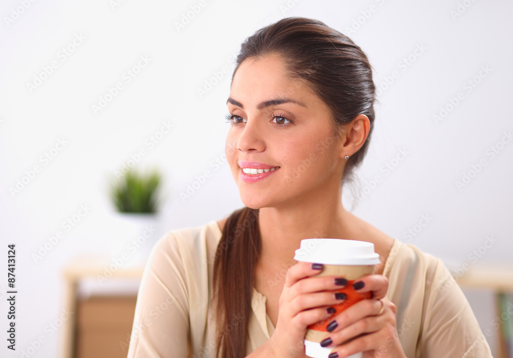 Beautiful businesswoman enjoying coffee in bright office Beautiful businesswoman enjoying coffee in bright office