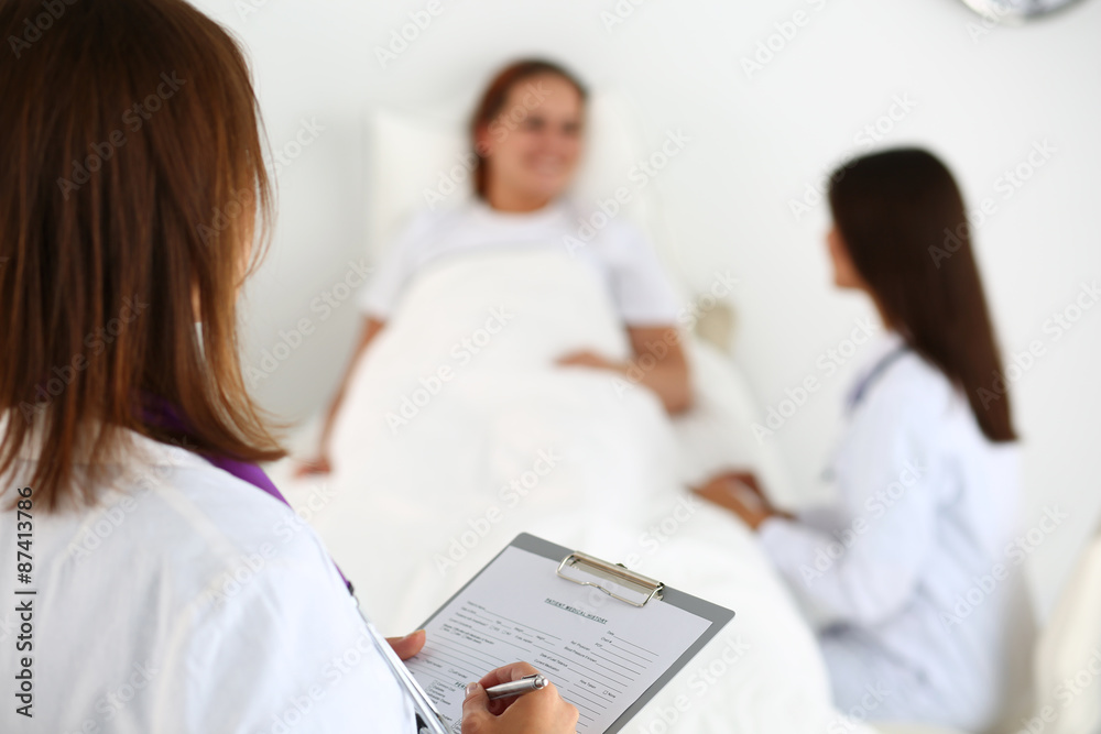 Female medicine doctor filling in patient medical history list d