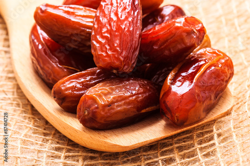 dried dates on wooden spoon cloth background