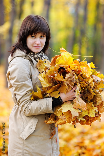 Beautiful young woman with autumn leaves