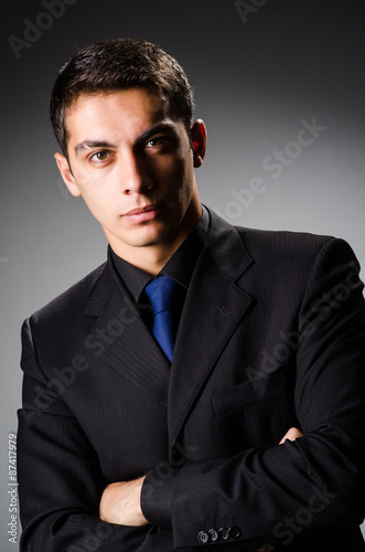 Young elegant man against gray