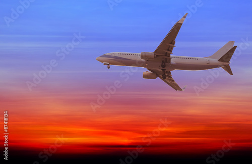 Commercial airplane flying at sunset