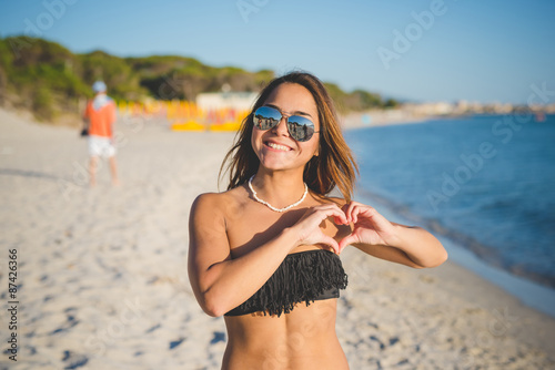 young beautiful brasilian woman making heart love photo