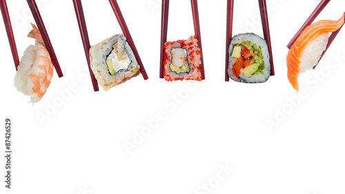 Many different sushi and rolls in chopsticks isolated on white background