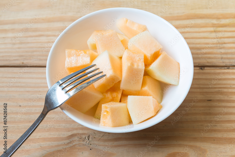 Cantaloupe in white dish with fork 2 Cantaloupe in white dish with fork 2