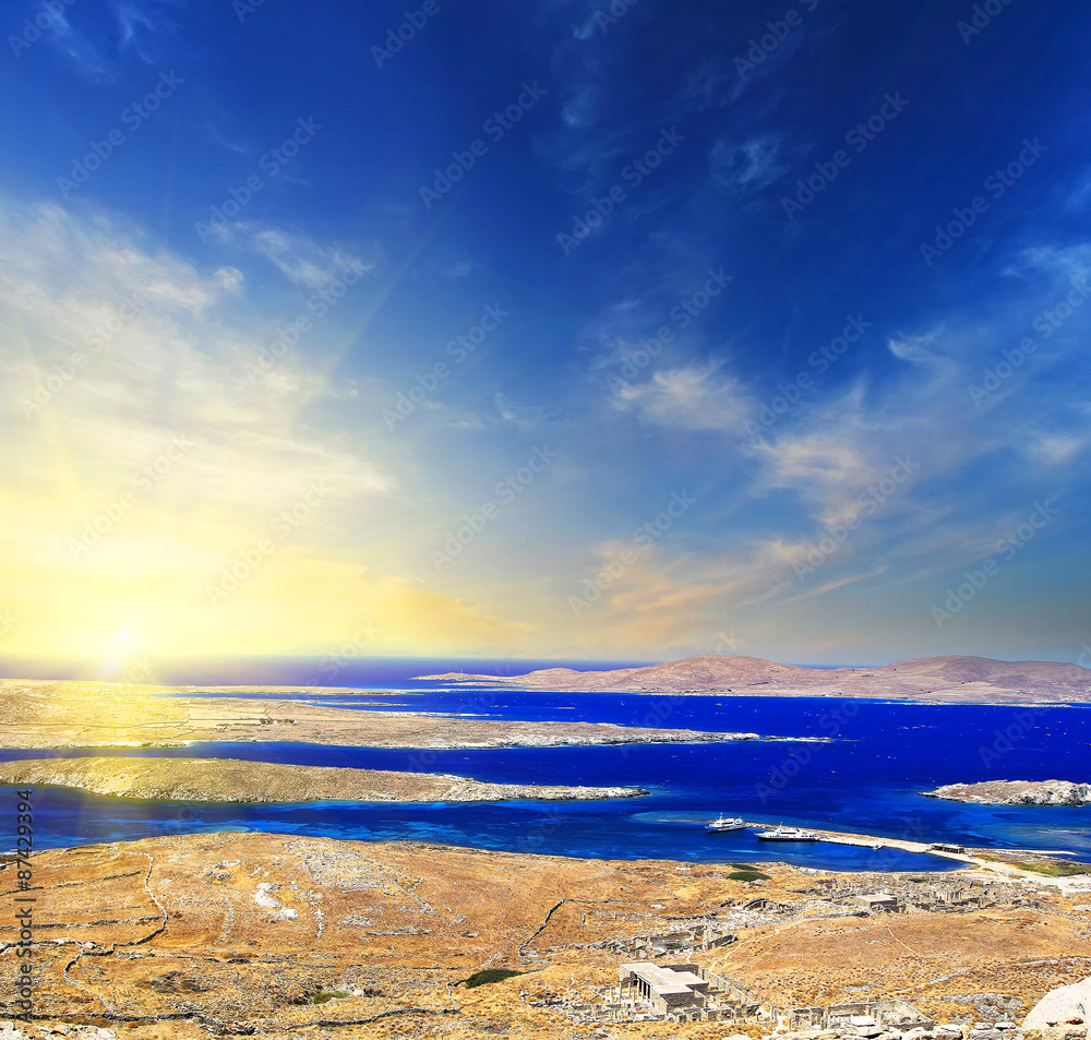 Fototapeta premium A panorama of sunset over Delos island, Greece with a shipwreck on the sandy beach