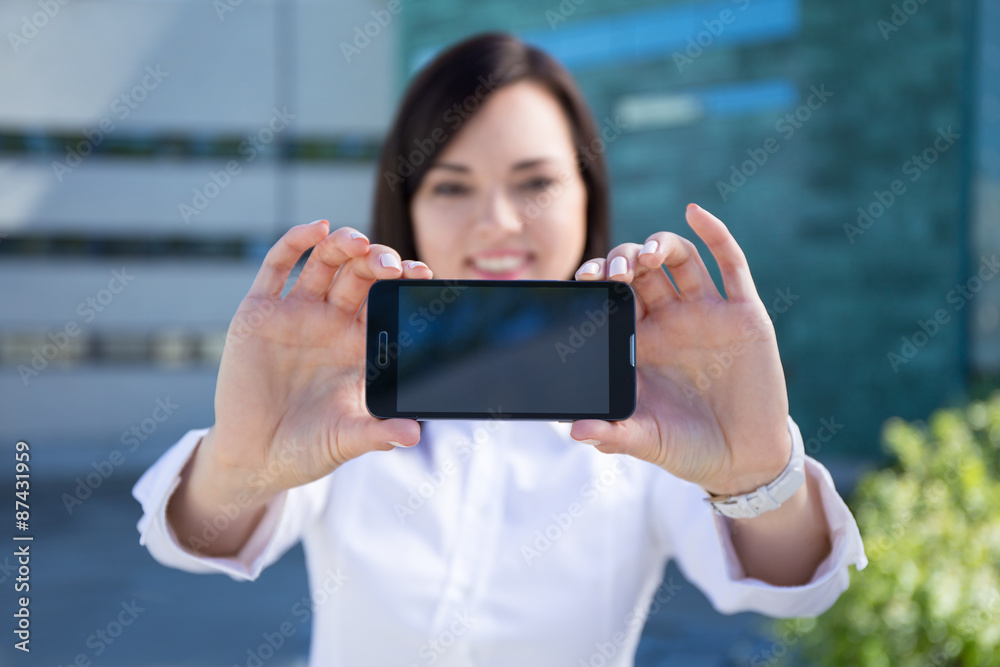 young beautiful business woman showing smartphone with blank scr