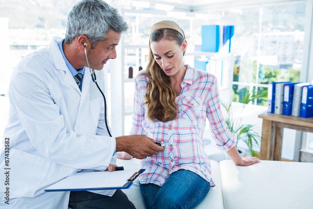 Obraz premium Doctor examining a pregnant woman with a stethoscope