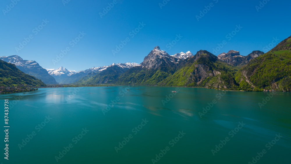 Panorama of Swiss Alps, peaks covered with snow.  Lake Uri in central Switzerland. Gorgeous summer day and clean bright blue sky