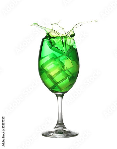 Green water spread in a wine glass isolated on white.