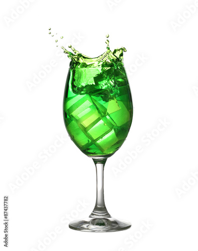 Green water spread in a wine glass isolated on white.