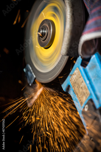 Grinding machine in action with bright sparks. Construction and manufacturing theme.