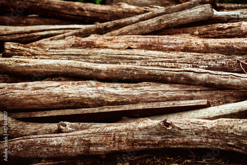 Heap of aged brown wooden logs as a natural background