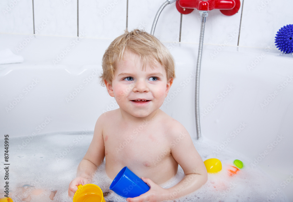 Adorable toddler boy having fun in bathtub Adorable toddler boy having fun in bathtub