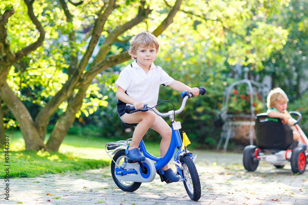 Little preschool kid boy riding with bicycle in summer Little preschool kid boy riding with bicycle in summer
