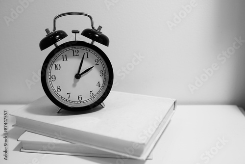 black and white vintage clock on bed side table