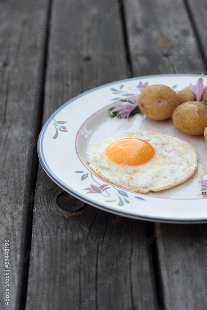 Fried egg with cooked potatoes on a white plate. Fried egg with cooked potatoes on a white plate.