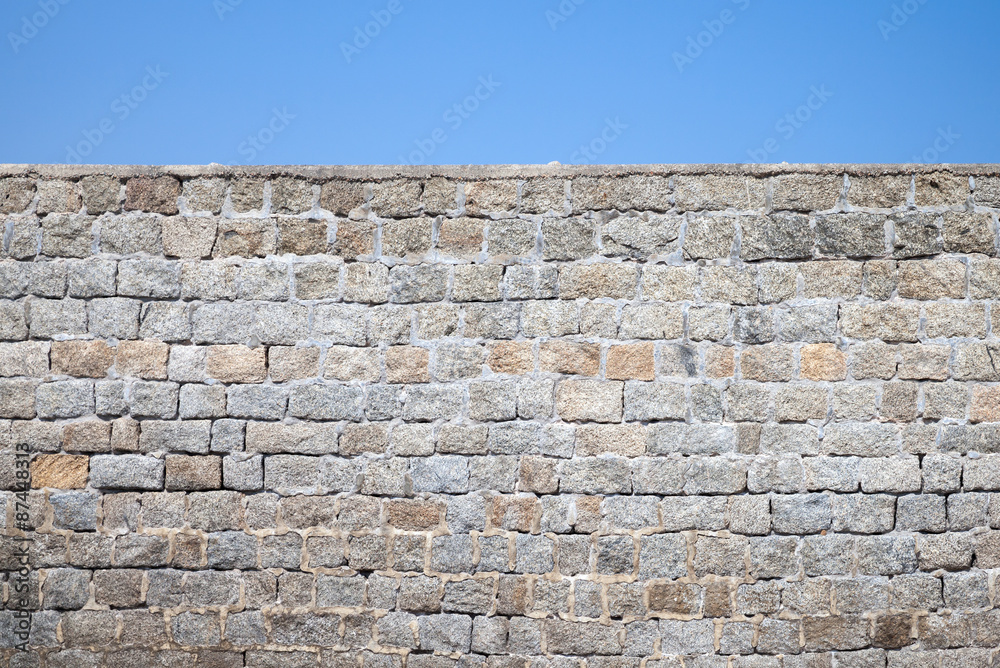 Old gray stone wall and blue sky