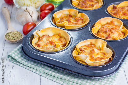 Homemade lasagna cups with minced meat, bolognese sauce topped with cheese