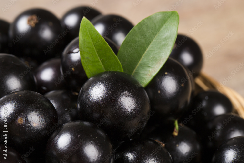 Berry Jaboticaba in bowl on wooden table Berry Jaboticaba in bowl on wooden table