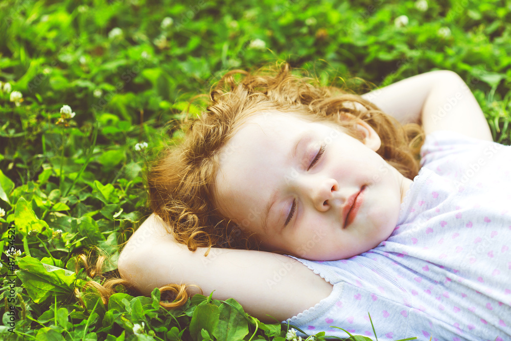 Sweet little girl sleeping on a green grass. Sweet little girl sleeping on a green grass.