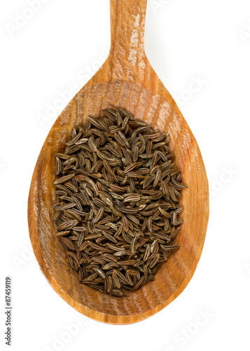 dried cumin in a wooden spoon photo