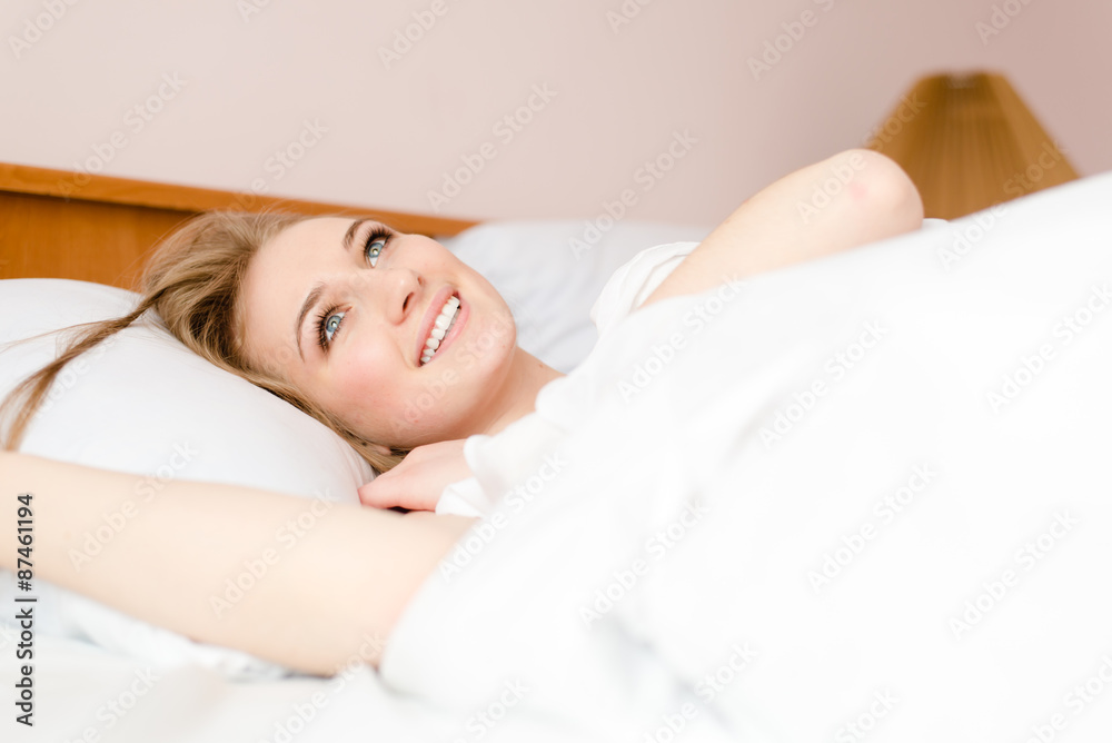 Relaxing lying in white bed and looking up Relaxing lying in white bed and looking up