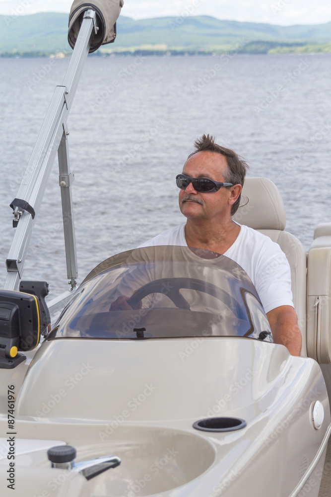mature men driving a pontoon boat on a lake