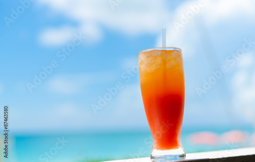 The Caribbean lifestyle symbol, Caribbean Cocktail bright orange against blurred sea and sky background.