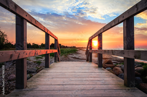 Sun rising at beach on bridge