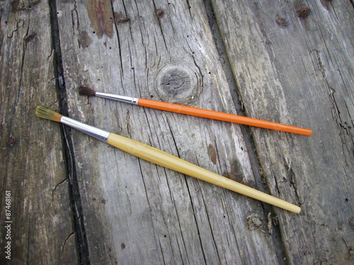 Paint brushes on wooden background