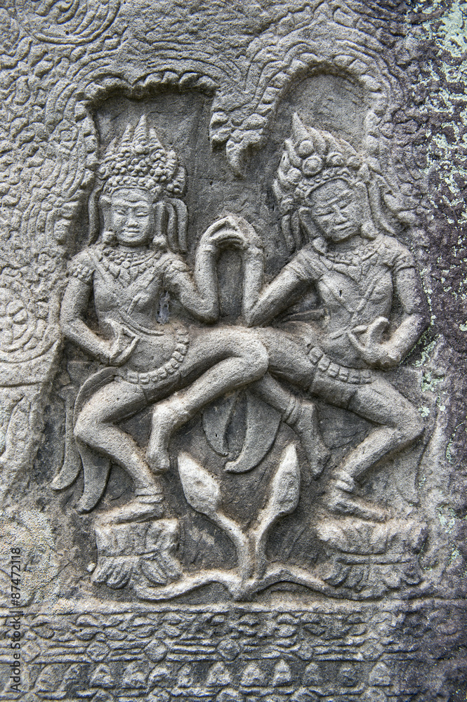 Sculptural relief in stone carving of traditional female goddesses known as apsara dancers at Angkor Wat, Cambodia