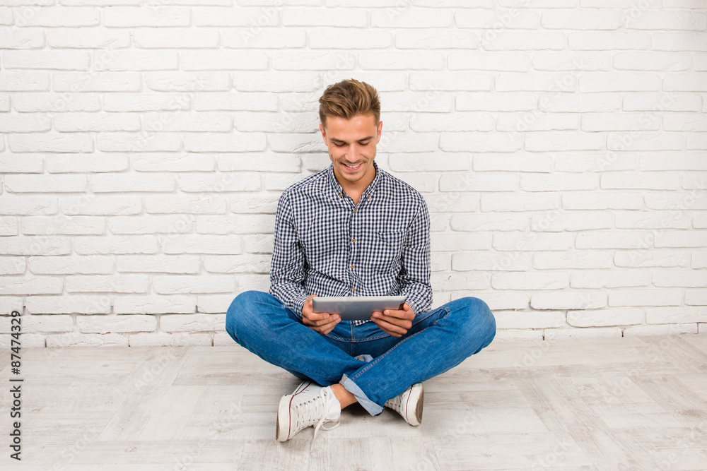 man sitting on the floor with digital tablet man sitting on the floor with digital tablet
