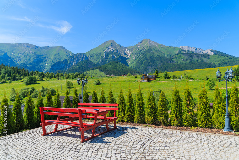 Fototapeta premium Picnic table on Zdiar village with view of Tatry Bielskie Mountains in summer, Slovakia