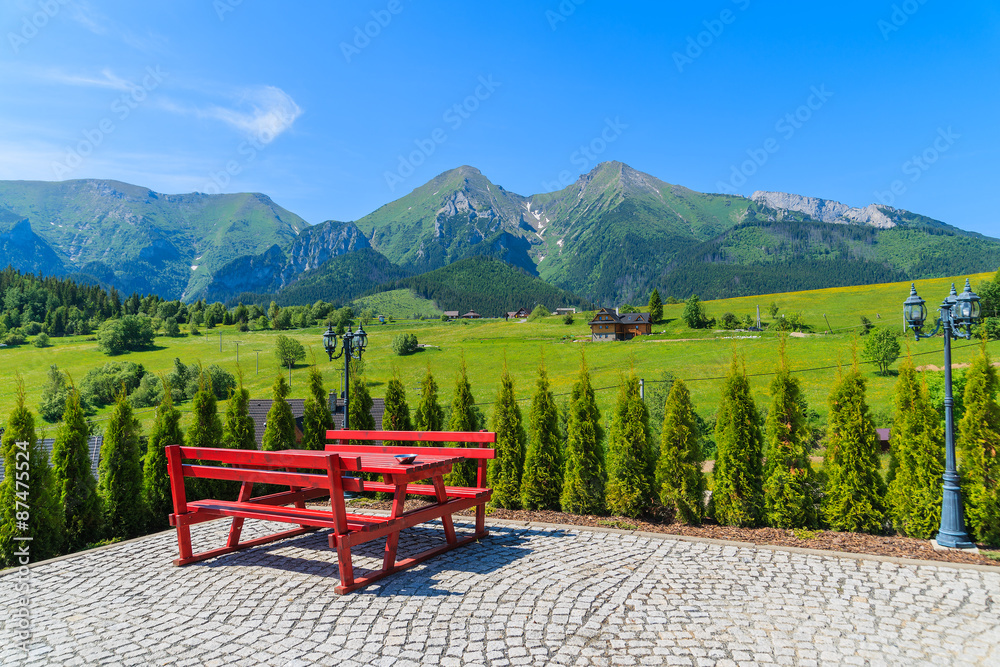 Obraz premium Picnic table on Zdiar village with view of Tatry Bielskie Mountains in summer, Slovakia