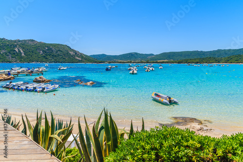 View of Santa Giulia beach with boats on azure sea water, Corsica island, France