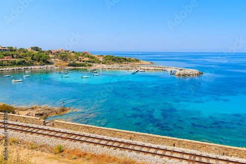 Railway track along beautiful bay in Algajola village on coast of Corsica island, France