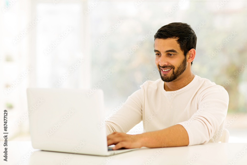 Fototapeta premium young indian man using laptop