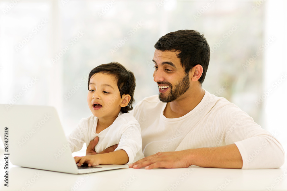 Obraz premium little indian boy using laptop with his father