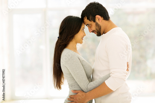 young couple hugging at home