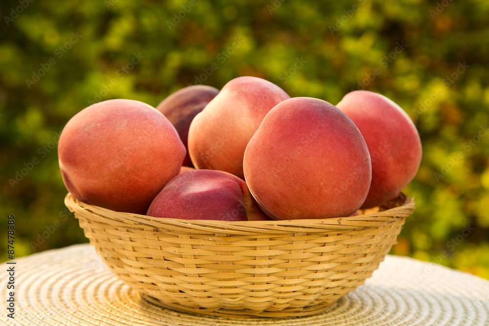 Some peaches in a basket over a wooden surface Some peaches in a basket over a wooden surface