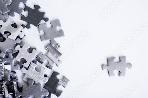 Jigsaw shot on a white background from above with one piece standing out