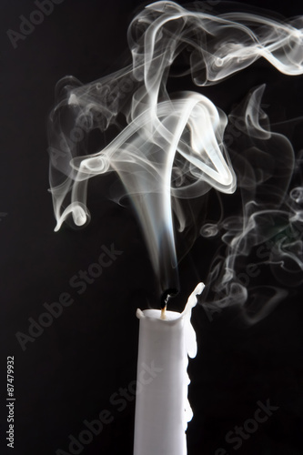 the smoke of an extinguished candle on black background